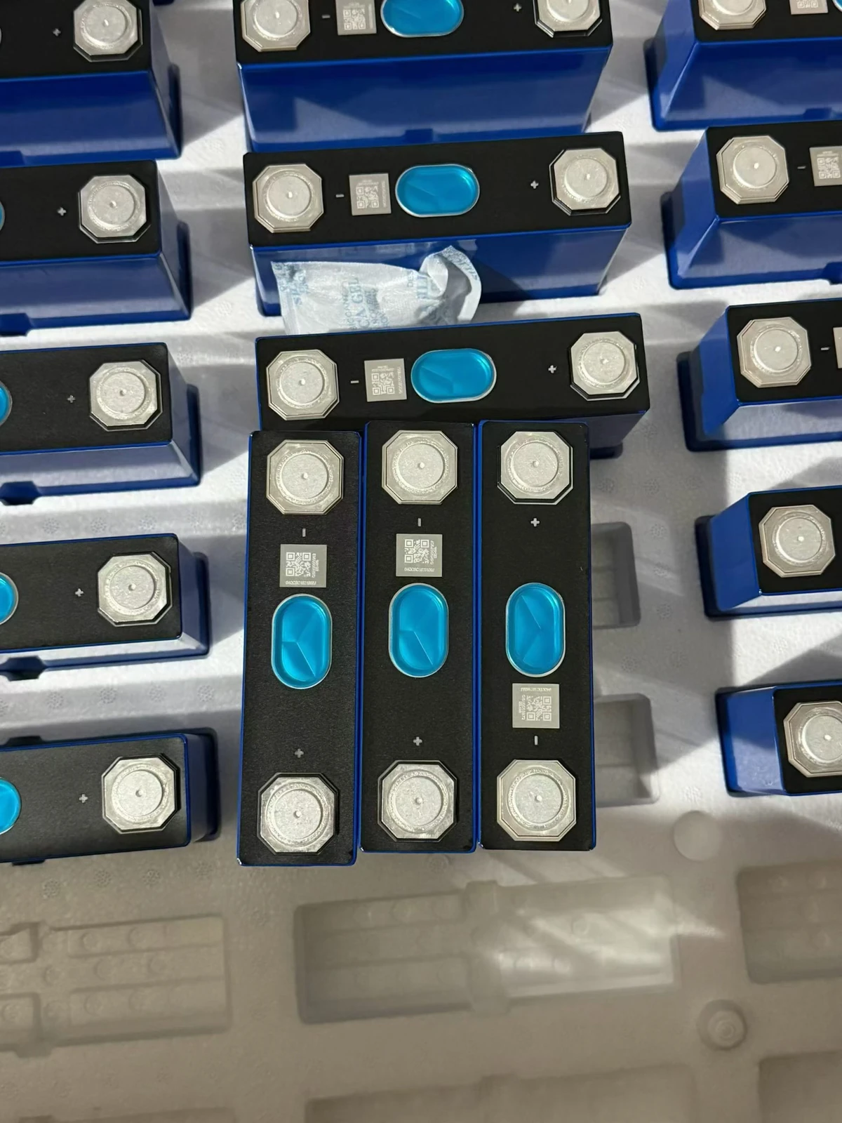 User-supplied photograph showing the tops, terminals and blue bodies of cells identified by the user as EVE 50Ah; exact model revision unconfirmed